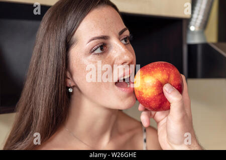 La main des hommes rss une pomme belle femme de rousseur avec une bouche ouverte, close-up Banque D'Images