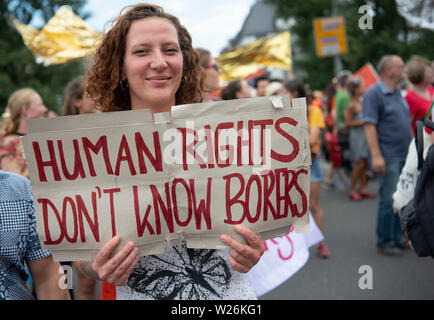 Hessen, Allemagne. 6 juillet 2019. 06 juillet 2019, Hessen, Frankfurt/Main : plusieurs centaines de participants prennent part à une manifestation dans le centre-ville pour soutenir les sauveteurs en mer et les réfugiés. Une femme est une pancarte avec l'inscription 'Les droits de l'homme ne connaissent pas de frontières". Photo : Boris Roessler/dpa Banque D'Images