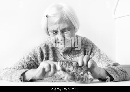 Photo gros plan détaillé de womans mains âgées méconnaissable restants de comptage de pièces dans son portefeuille de retraite après le paiement des factures. Banque D'Images