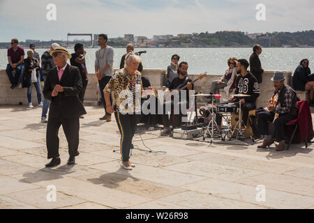 Vieux couple danse de rue de la rue des musiciens en face de touristes par le Tage (l) à la Praça do Comêrcio, Lisbonne, Portugal. Banque D'Images