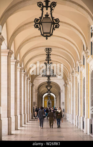 Les piétons marcher l'impressionnante galerie de ronde sous les immeubles gouvernementaux par l'Arco da Rua Augusta au large de la Praça do Comércio, Lisbonne, Portugal Banque D'Images