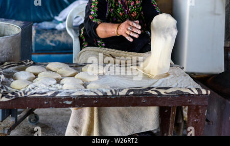 Portrait vieille femme arabe part la cuisson du pain plat ou laffa ou du pain pita pour le ramadan de l'Arabe. Banque D'Images