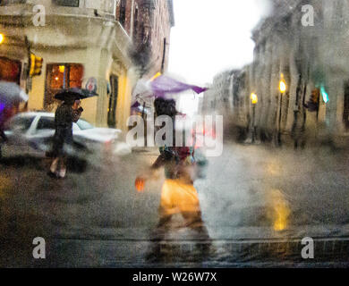 Sous la pluie de marche des piétons dans le centre-ville de Philadelphie, tourné à travers un pare-brise de voiture couvert pluie Banque D'Images