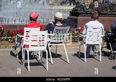 Moscou, Russie - le 2 juillet 2019 , trois retraités en majuscules s'asseoir sur des chaises en fer à la fontaine à la Fleur de pierre VDNKH près de la fontaine. Banque D'Images