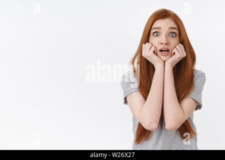 Choqué la panique peur jeune fille rousse inquiète yeux popping air effaré concerné Tenez les mains tremblantes jawline crier horrifiés, regarder Banque D'Images