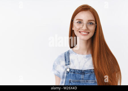 Sortant joyeuse belle Rousse fille européenne rouge longue hairstyle portent des lunettes smiling cheerful, écouter une conversation animée, stand ba blanc sans souci Banque D'Images