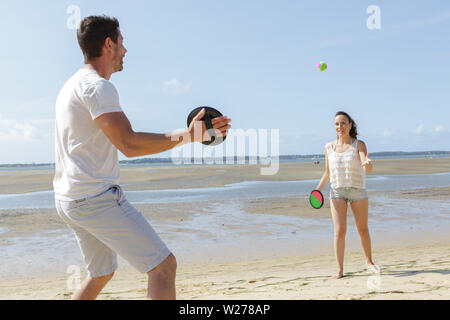 Amis jouant sur la plage Banque D'Images