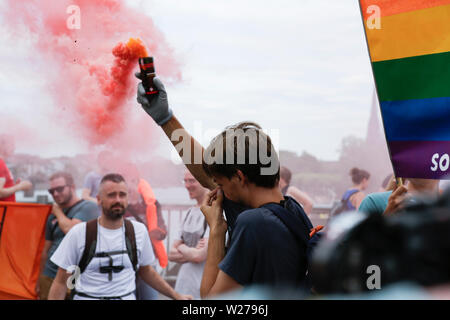 Francfort, Allemagne. 6 juillet 2019. Un manifestant a lancé une fusée avec la fumée rouge. Plus de 1 000 personnes ont défilé à Francfort, à appeler pour enregistrer les réfugiés, à la fin de la criminalisation de sauvetage en mer et une disposition de ports pour enregistrer les réfugiés en Europe. Cette manifestation s'inscrivait dans le cadre d'une large protestation Seebrucke allemande sous le slogan de "l'état d'urgence de l'humanité", qui a eu lieu après 3 Sea-Watch allemand le capitaine Carola Rackete a été arrêté en Italie pour secourir les réfugiés en Méditerranée et de les traduire en Italie. Banque D'Images