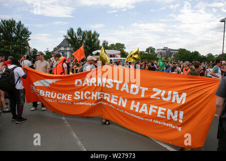 Francfort, Allemagne. 6 juillet 2019. Les manifestants portent une bannière qui est la suivante : "en tant qu'armstadt enregistrer habour'. Plus de 1 000 personnes ont défilé à Francfort, à appeler pour enregistrer les réfugiés, à la fin de la criminalisation de sauvetage en mer et une disposition de ports pour enregistrer les réfugiés en Europe. Cette manifestation s'inscrivait dans le cadre d'une large protestation Seebrucke allemande sous le slogan de "l'état d'urgence de l'humanité", qui a eu lieu après 3 Sea-Watch allemand le capitaine Carola Rackete a été arrêté en Italie pour secourir les réfugiés en Méditerranée et de les traduire en Italie. Banque D'Images