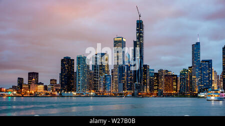 Chicago Illinois d'horizon, l'heure du coucher du soleil. Vue panoramique du front de mer de la ville de Chicago gratte-ciel lumineux, ciel nuageux dans la soirée Banque D'Images