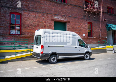 Compact blanc économique commerciale populaire mini cargo van pour des livraisons locales et les spécifications debout sur l'entrepôt de stationnement sur t Banque D'Images