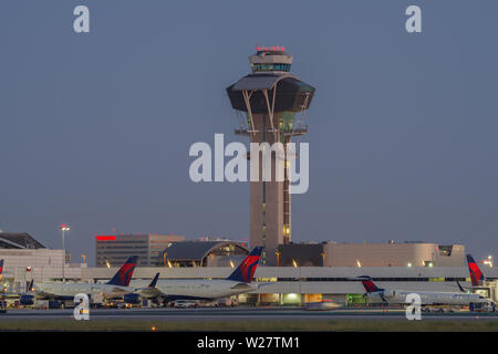 Image de la tour de contrôle et des jets de Delta Air Lines à l'embarquement à l'Aéroport International de Los Angeles, LAX, au crépuscule. Banque D'Images