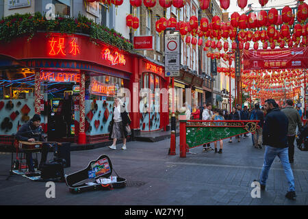 Londres, UK - avril 2019. Musicien de rue jouant de la guitare lors d'un spectacle à Chinatown. Banque D'Images