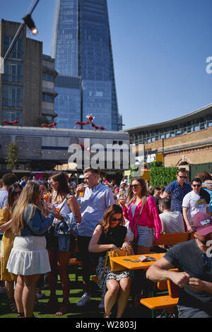 Londres, Royaume-Uni - mai 2019. Les jeunes ayant des boissons dans le vinaigre, de Cour une nouvelle cuisine de rue et marché de l'art près de London Bridge Station. Banque D'Images