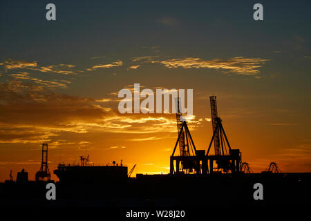 Grues aux ports d'Auckland au coucher du soleil, l'île du nord, Auckland, Nouvelle-Zélande Banque D'Images