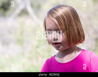 Close up de jeune fille en robe rose jouant dans le plein air Banque D'Images