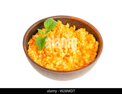 Cuvette d'argile brun avec du porridge isolé sur fond blanc. Banque D'Images