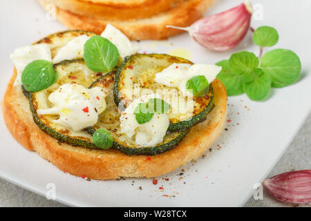 Bruschetta avec délicatesse ou poêlée de courgettes, fromage mozzarella, l'ail, de menthe et d'épices. Sandwich méditerranéen. Canape. Antipasti. Délicieux br Banque D'Images