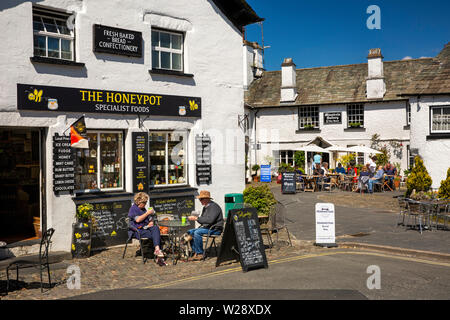 UK, Cumbria, Hawkshead, La Place, couple drinking café du matin à l'extérieur pot de café et magasin acress de square Gallery cafe de Ménestrel Banque D'Images