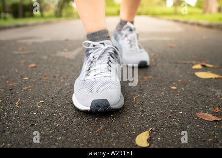 Jogging femme dans Central Park en portant des chaussures de sport de l'exercice dans la soirée coucher du soleil. Banque D'Images
