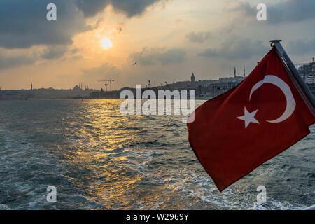 Waving Flag turc forment une croisière ferry le Bosphours au coucher du soleil avec l'horizon d'Istanbul dans l'arrière-plan, Turquie Banque D'Images