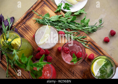 Les boissons d'été, un ensemble de limonades. Les limonades dans pichets sur la table, les ingrédients qui les composent sont disposés autour. Banque D'Images