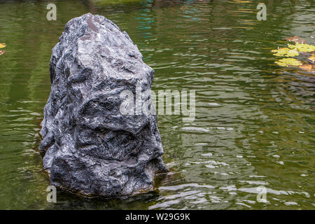 Big Black stones dans l'eau jardin contexte Banque D'Images