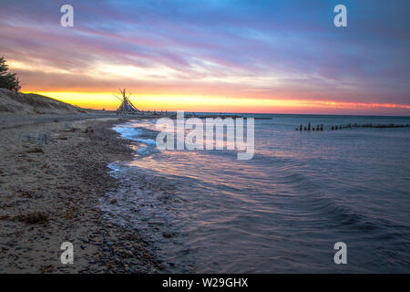 Coucher De Soleil Sur Michigan Beach. Coucher de soleil sur la côte sauvage du lac supérieur avec cabane de plage à l'horizon dans la péninsule supérieure du Michigan à Whitefish point. Banque D'Images