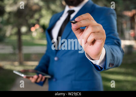 Businessman est titulaire d'un stylo et points en l'espace de copie. Homme avec lap top et un stylo dans la main. Banque D'Images