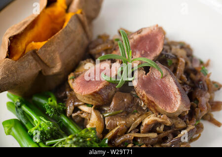 Un plat de venaison fait maison composé de chevreuil filet de selle, ou l'aide, qui a été donc il est frit flash encore rares et tranchées. Il est servi avec Banque D'Images