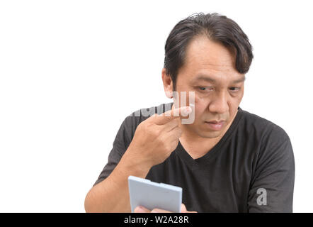 Homme asiatique d'âge moyen l'application de crème sur le visage avec le mélasma ou défaut et taches brunes de la peau ou de produit de beauté. concept. Banque D'Images