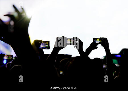 La collecte de mémoire numérique perd de capacité d'être présent, silhouette de personnes la prise de concert avec les téléphones mobiles Banque D'Images