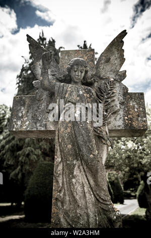 Un ange en pierre sculpté dans le jardin du souvenir de la ville de Gillingham à Dorset. Photographie numérique désaturée. Dorset Angleterre GB Banque D'Images