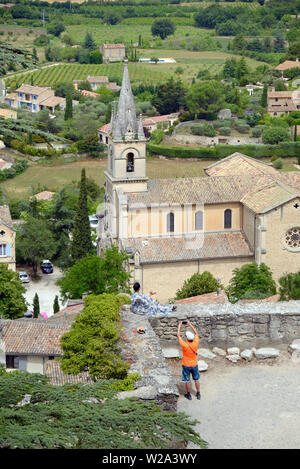 Les touristes profiter de vue sur Bonnieux et sa nouvelle église, construite en 1870, avec la vallée du Calavon ordinaire ou dans le Parc Naturel Régional du Luberon Provence France Banque D'Images