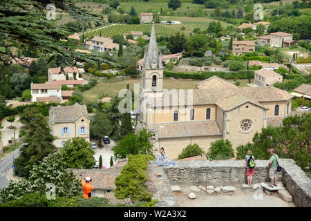 Les touristes profiter de vue sur Bonnieux et sa nouvelle église, construite en 1870, avec la vallée du Calavon ordinaire ou dans le Parc Naturel Régional du Luberon Provence France Banque D'Images