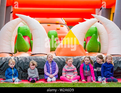 Défi du labyrinthe, Dalkeith Country Park, Midlothian, Ecosse, Royaume-Uni. Les enfants attendent patiemment pour l'ouverture la plus longue du monde de course d'obstacles gonflable Banque D'Images