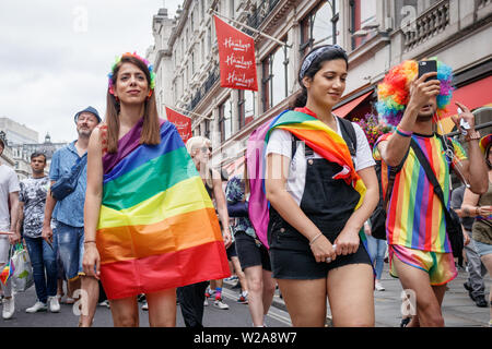 Londres, Angleterre, Royaume-Uni. 6 juillet, 2019. Les filles enveloppés dans des drapeaux arc-en-ciel le long d'Oxford Circus pendant la parade.La fierté de Londres 2019 Jour de la parade est un événement organisé par la fierté de Londres. C'est un défilé de gens de tous les sexes, sexualités, races, nationalités, d'origines et de religions en cours de formation pour la célébration de la fierté le plus grand du Royaume. Le centre de Londres était couvert de décorations à thème arc-en-ciel, symbole de l'inclusivité. Credit : Belinda Jilao SOPA/Images/ZUMA/Alamy Fil Live News Banque D'Images