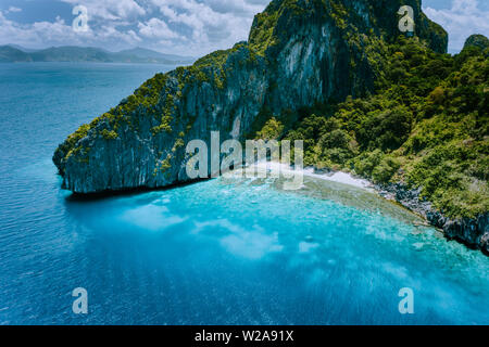 Drone aérien vue de l'île tropicale Entalula. D'immenses falaises de roches abruptes montagnes qui entourent la baie bleu avec de magnifiques récifs coralliens. Island hopping tour Banque D'Images