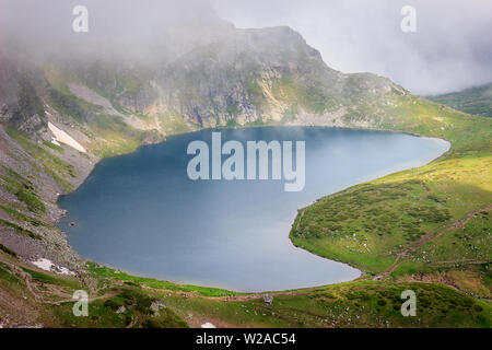 Belle vue du célèbre Misty Lake rénale sur la montagne de Rila en Bulgarie, paysage ensoleillé et des centaines de randonneurs de montagne randonnée sur les hauts plateaux Banque D'Images