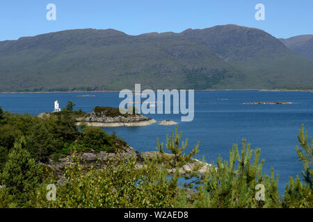 Phare de Plockton sur l'île d'Eilean-a-Chait avec décor de montagnes, vu de l'Rudha Mor pointe à pied. Banque D'Images