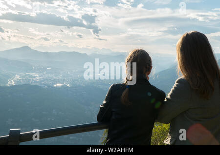 Femme et sa fille appréciant le lever du soleil du haut d'une montagne. Banque D'Images