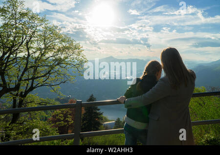 Femme et sa fille appréciant le lever du soleil du haut d'une montagne. Banque D'Images