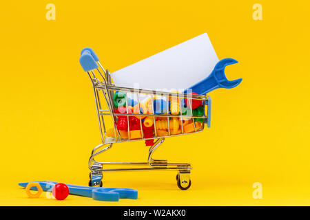 Panier Panier avec des outils clés bleu et plein d'une vis de couleur sur fond jaune Banque D'Images