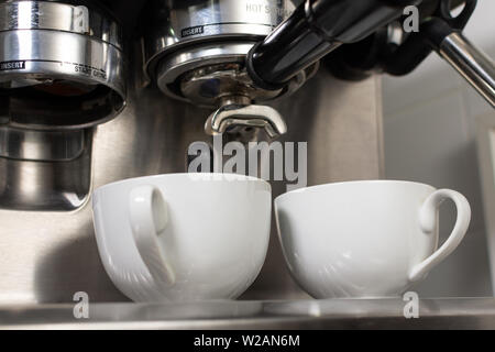Machine à café de l'extraction du café dans deux tasses Banque D'Images