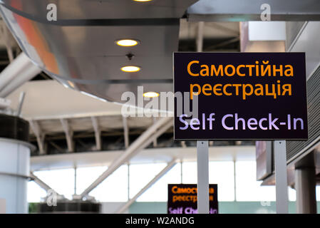 Pointeur avec une inscription en ukrainien - l'enregistrement à l'aéroport. Le stand d'information, l'auto-enregistrement de bord Banque D'Images