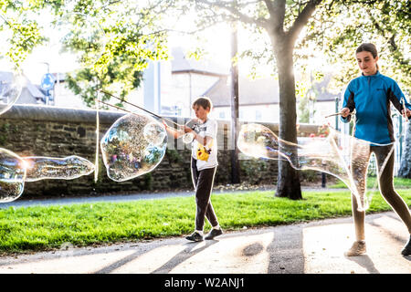 Pays de Galles Aberystwyth UK, Dimanche 07 Juillet 2019 Royaume-Uni Météo : une famille dans le parc à Aberystwyth et s'amuser en jouant avec bulle de savon géante dans le soleil du soir à la fin de l'été dans l'ouest du pays de Galles. Crédit photo : Keith Morris/Alamy Live News Banque D'Images