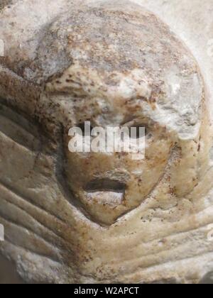 Close-up de l'angle d'un sarcophage en pierre avec un visage sculpté montrant les yeux, le nez et la bouche Banque D'Images