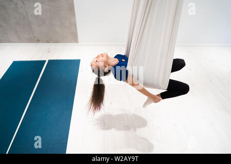 Portrait d'une belle jeune fille engagée dans fly yoga sur toiles. Banque D'Images