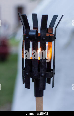 Cité médiévale lanterne en métal brûlant dans la nuit. Lampe de fer noir avec la flamme sur le support en bois sur knights festival. Concept historique et médiéval. Banque D'Images