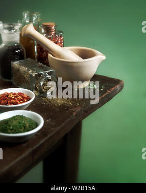 Vintage mortier et pilon avec épices et herbes sur table en bois Banque D'Images